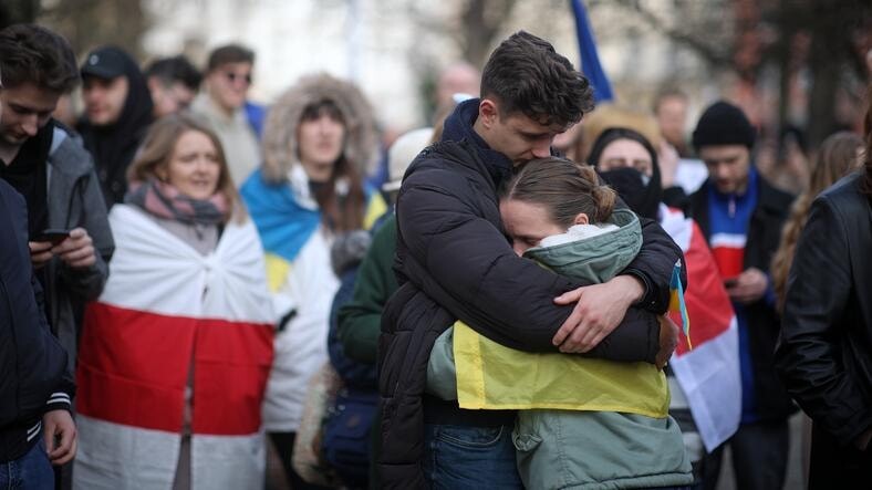 Ludzie z flagami Polski i Ukrainy. Przytulają się